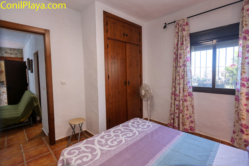 Dormitorio con armario empotrado y ventana decorada con cortinas floreadas