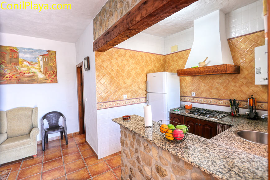 Cocina rústica con barra americana y mobiliario tradicional desde el salón