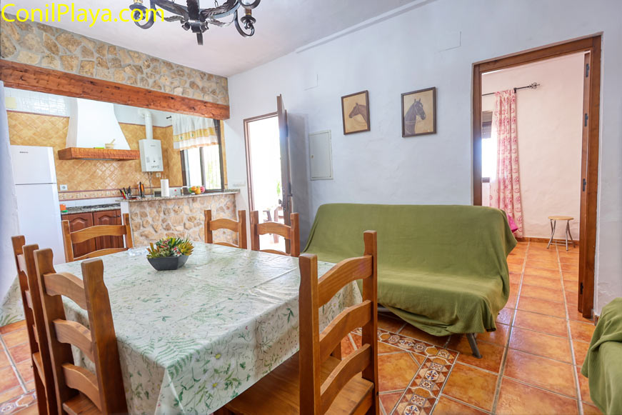 Comedor amplio con mesa de madera y sofá junto a la cocina abierta