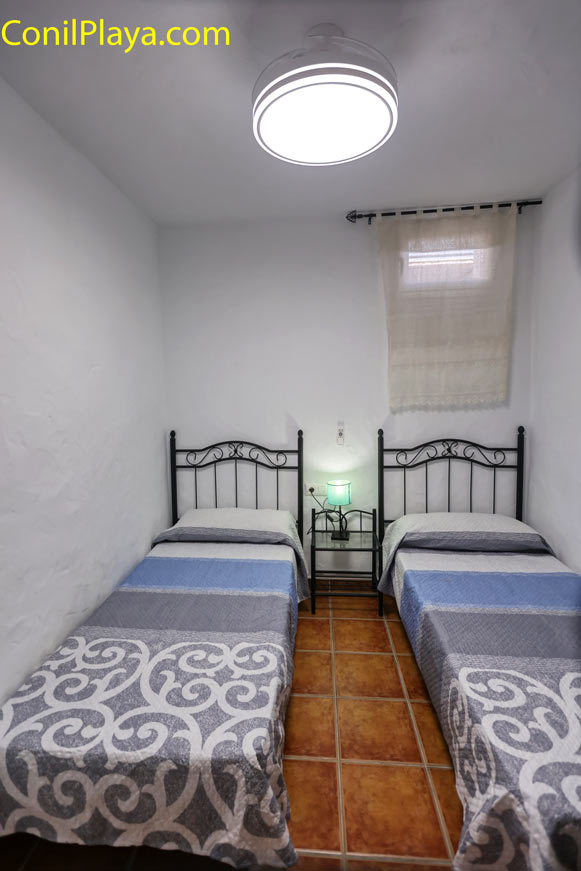 Dormitorio interior con dos camas individuales y lámpara de mesa entre ellas