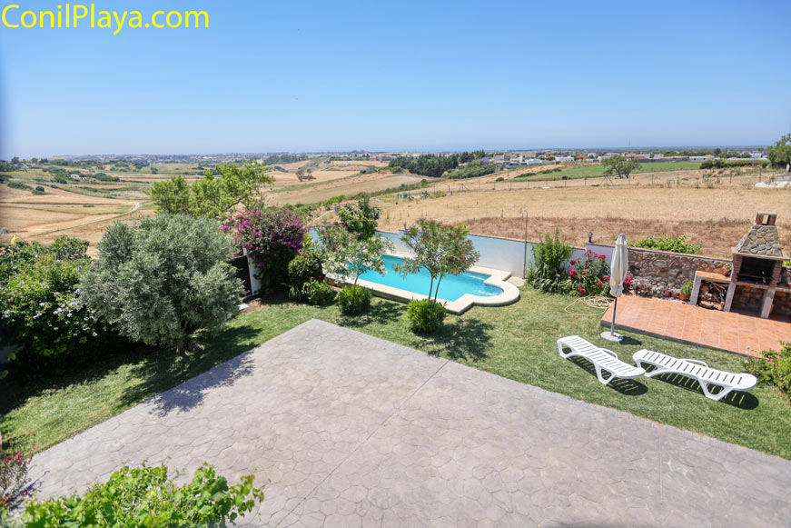 Zona exterior con piscina privada, tumbonas y barbacoa junto a jardín cuidado