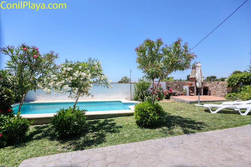 Zona de piscina privada junto a jardín y área de barbacoa