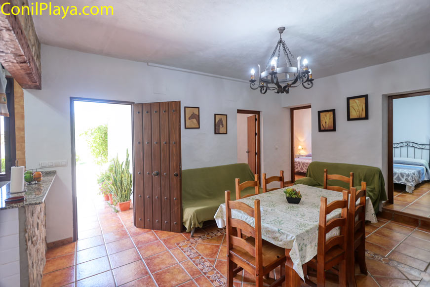 Comedor rústico con mesa de madera y salida hacia un patio interior
