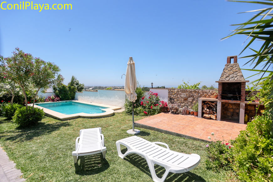 Zona exterior con piscina privada, tumbonas y barbacoa de piedra vistas al jardín