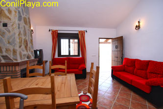 mesa del comedor de madera y al fondo los sofás del salón