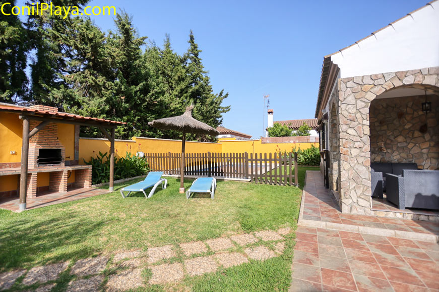 Porche con zona de descanso y barbacoa junto a jardín privado