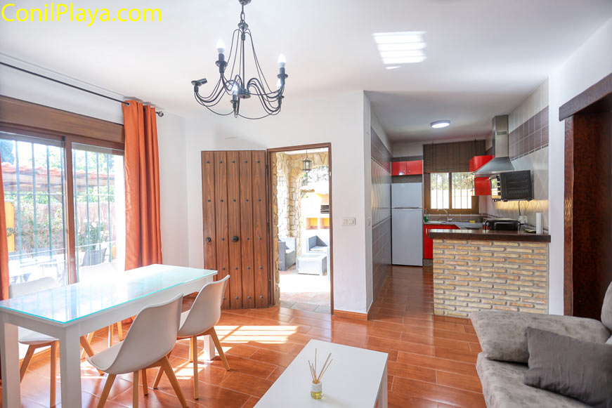 Comedor con mesa moderna junto a cocina abierta y puerta al exterior