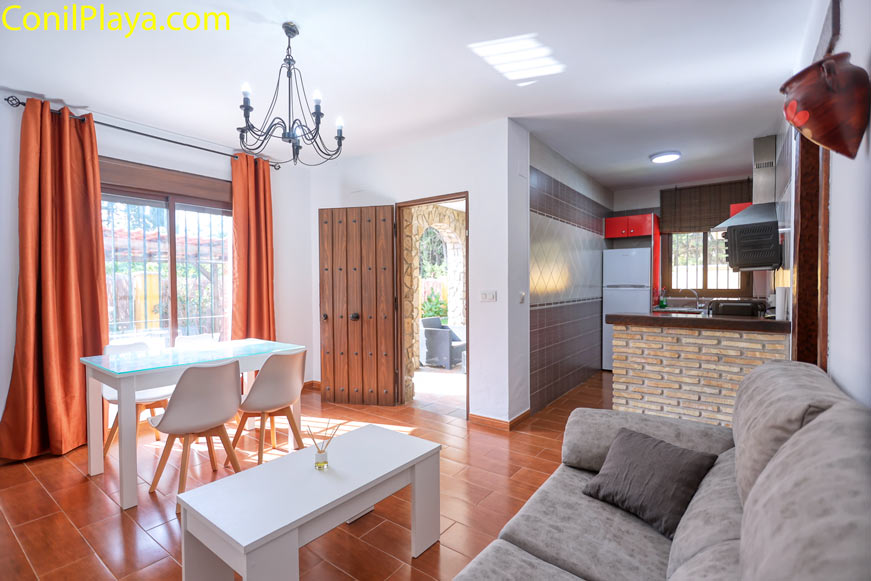 Salón con sofá mesa de centro y comedor junto a cocina abierta