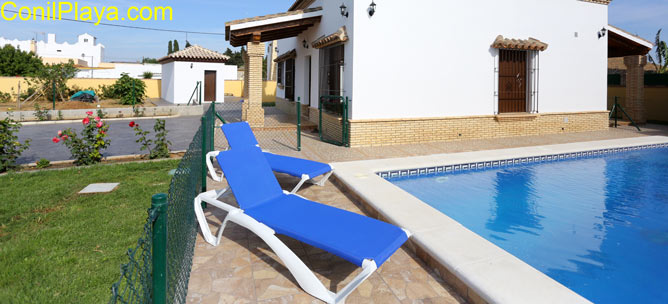 piscina y al fondo el jardín con césped