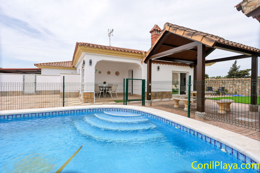 Vista del alojamiento desde la piscina privada y con el merendero que está junto a la barbacoa