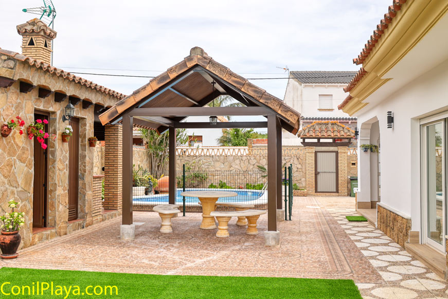 Merendero cubierto junto a la piscina y fachada