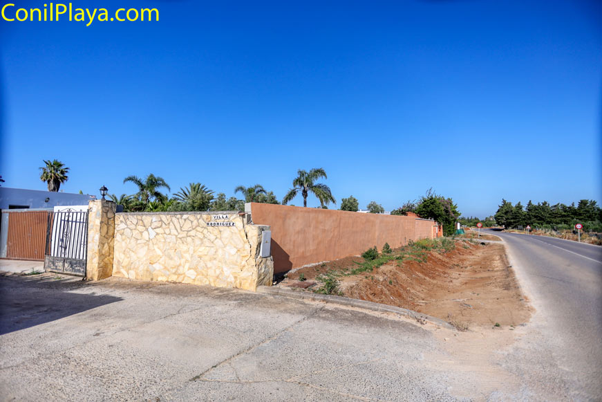 Entrada con muro de piedra y portón junto a carretera del muelle pesquero de Conil