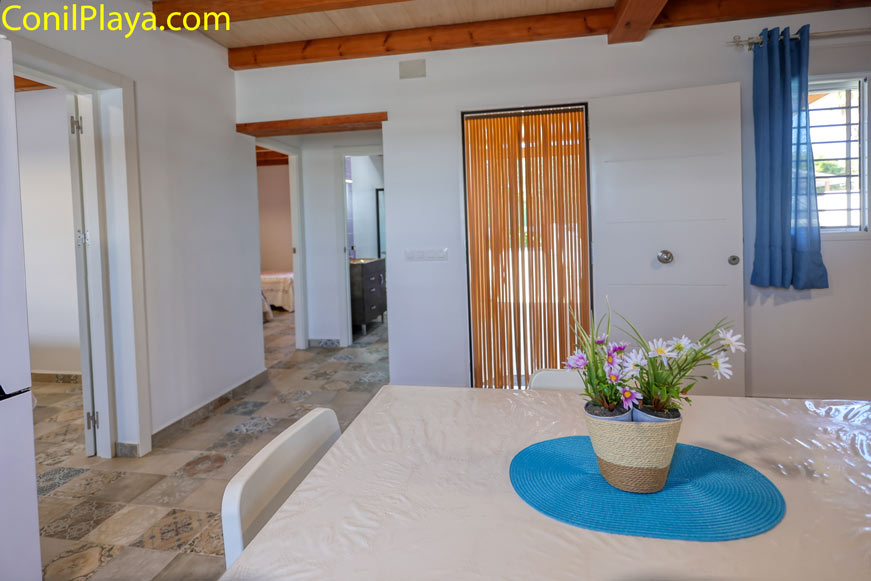 Mesa con centro de flores en cocina luminosa de vivienda vacacional