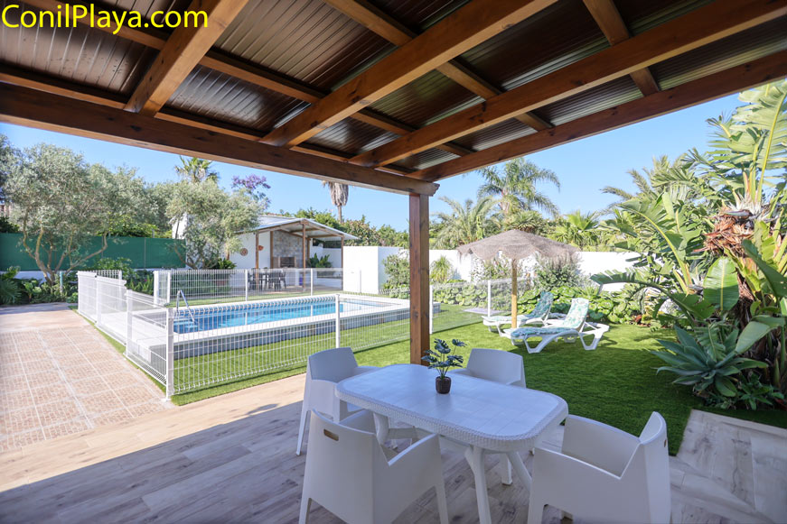 Mesa y sillas en el porche con vistas a piscina y jardín privado