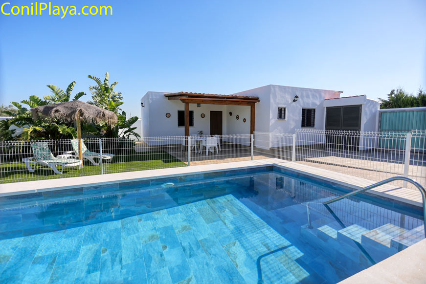 Piscina vallada junto a chalet con terraza y jardín privado