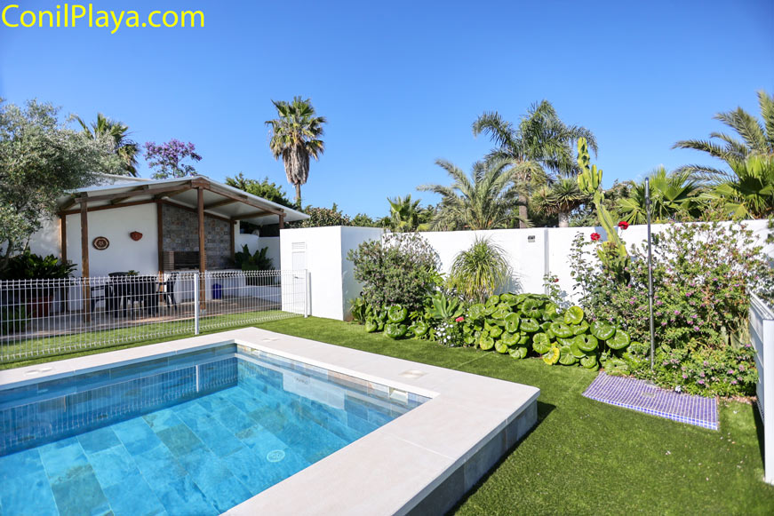 Piscina privada junto a jardín con porche y vegetación tropical