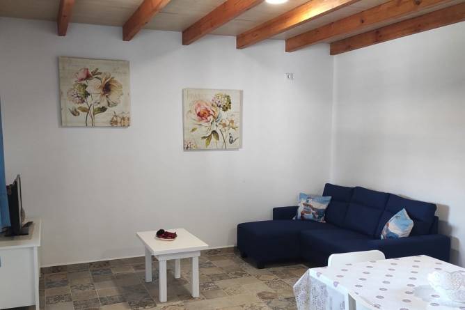 El sofá del salón es oscuro y de tipo chaise-longue