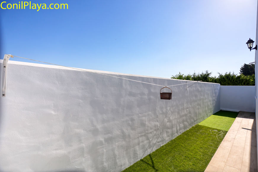 Jardín privado con césped artificial y tendedero para tender la ropa
