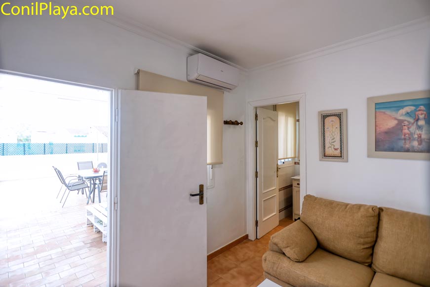 Salón con sofá aire acondicionado y acceso a terraza amueblada