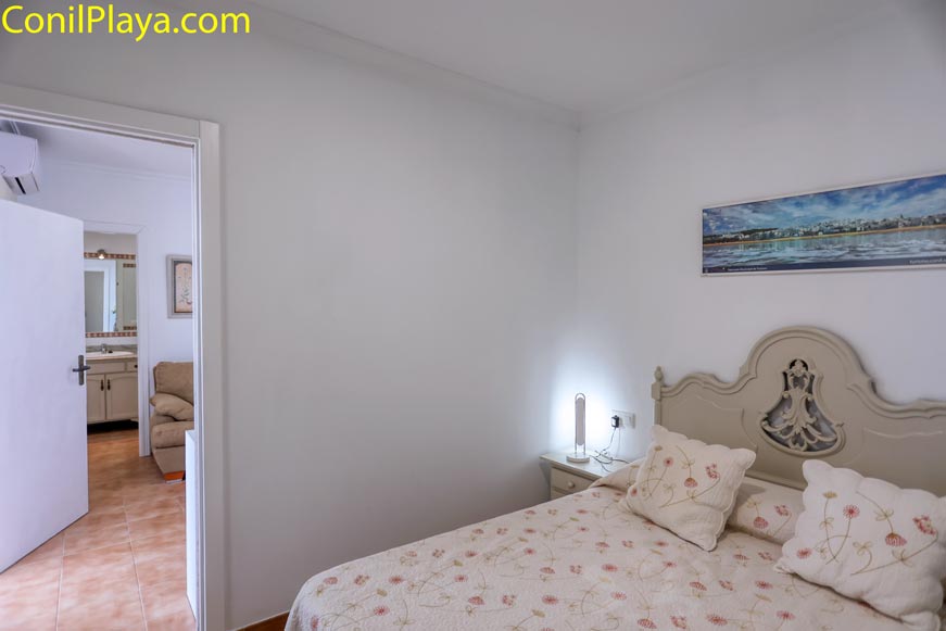 Dormitorio con cama doble y cabecero decorativo desde la puerta