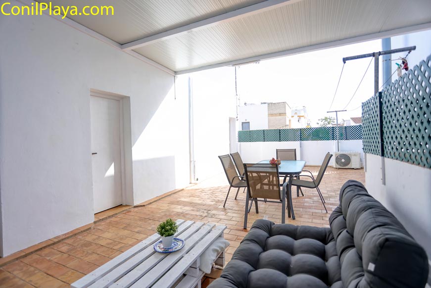 Terraza amplia con sofá, mesa y sillas vista desde la entrada