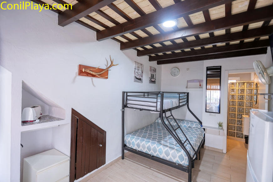 Dormitorio con litera metálica y detalles decorativos visto desde la entrada