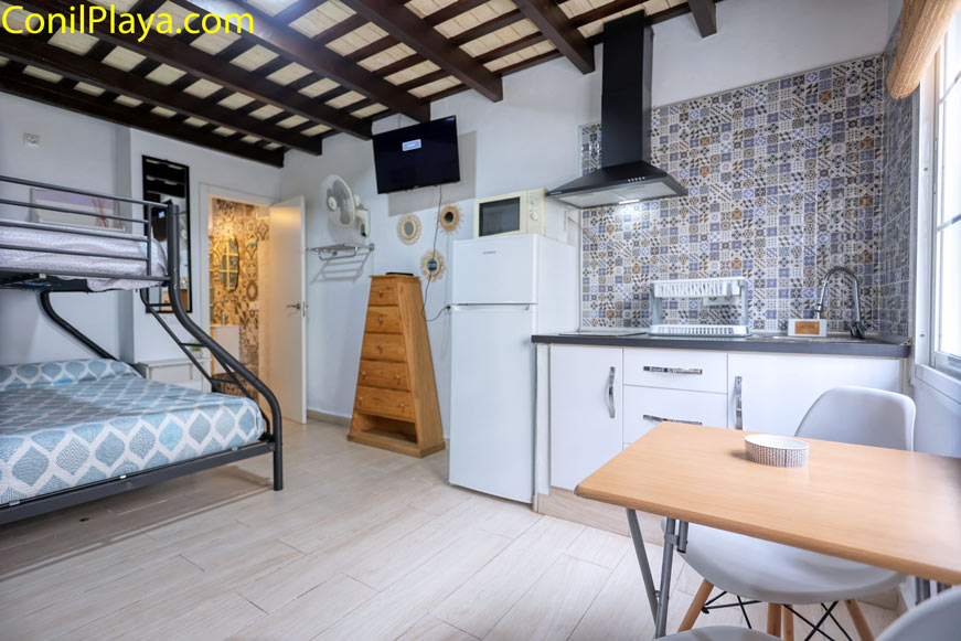 salón interior con sofá, cocina integrada y ventana amplia