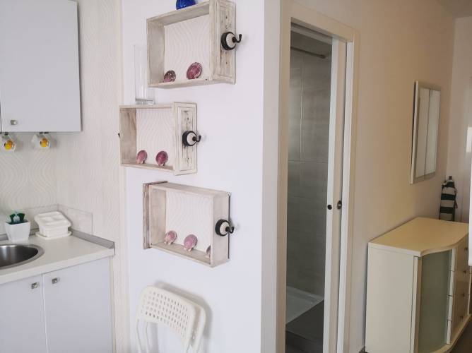 Vista parcial de cocina y entrada a baño con mobiliario moderno