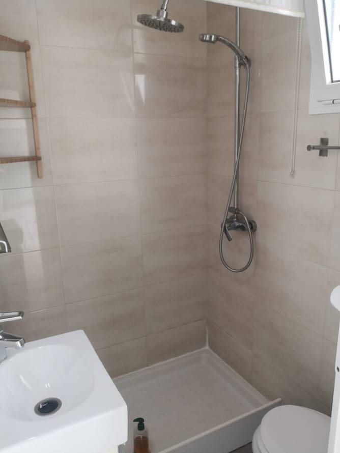 Ducha moderna con lavabo y ventana en cuarto de baño pequeño