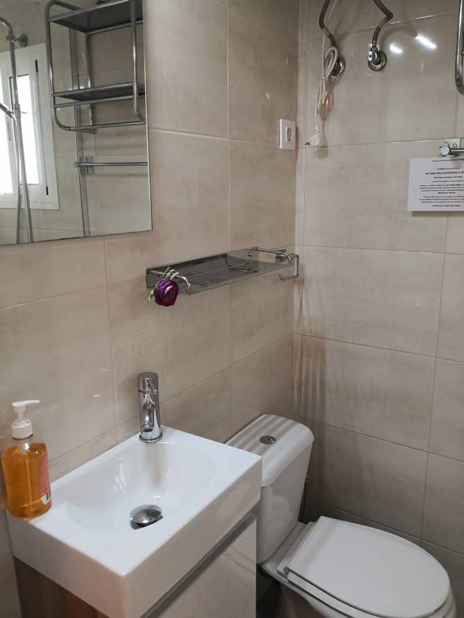 Lavabo pequeño con espejo y sanitarios en baño moderno y compacto