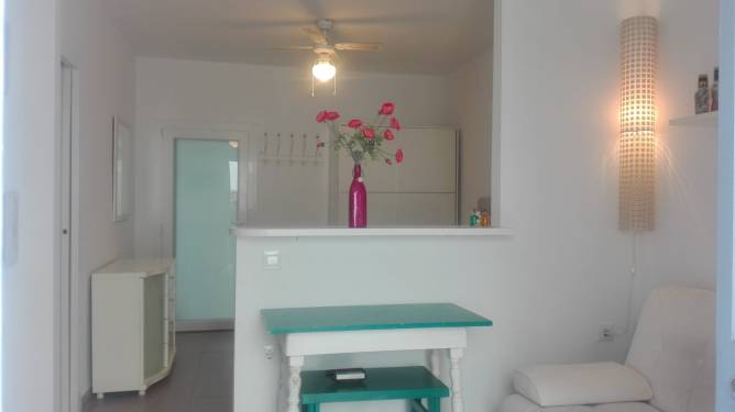 Salón con mesa pequeña y decoración en tonos claros