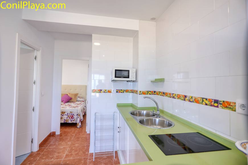 Cocina moderna con barra verde y fregadero doble vista desde la entrada