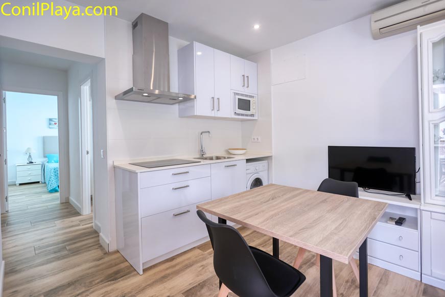 Vista general del apartamento con la mesa comedor, la cocina y el dormitorio al fondo