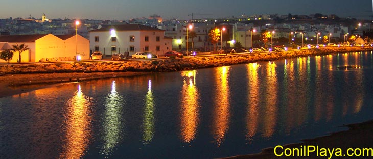 Foto nocturna de Conil realizada desde el puente del rio salado con marea alta.