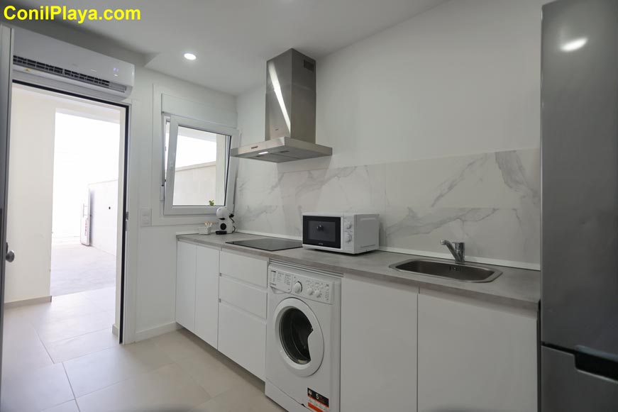 Cocina moderna con electrodomésticos y salida directa a patio interior