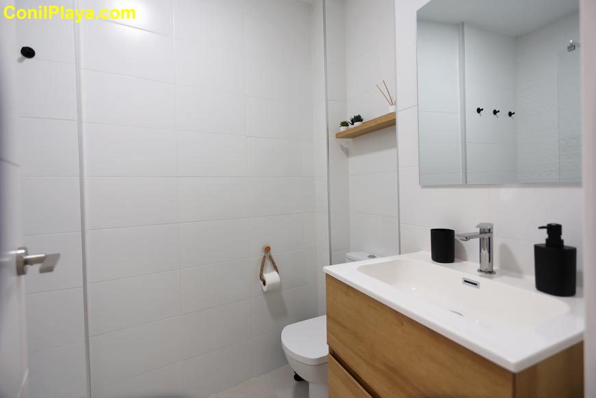 Lavabo con cajones del cuarto de baño y sanitario visto desde la entrada