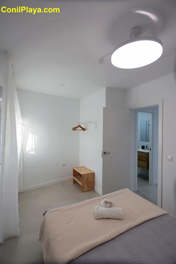 Vista general del dormitorio principal con ventilador de techo y acceso a cuarto de baño privado