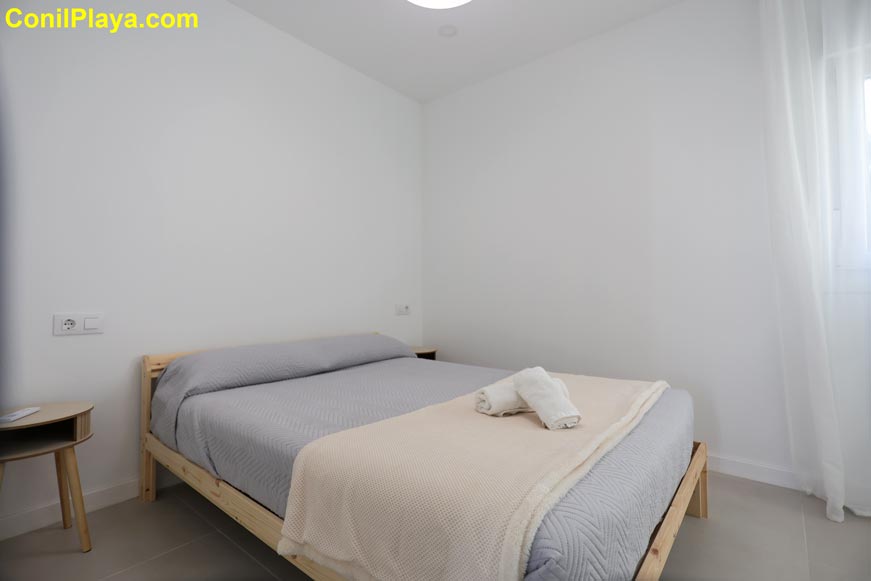 Dormitorio principal con cama doble y decoración minimalista