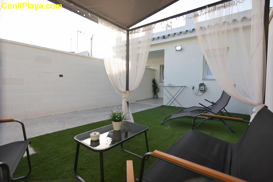 Patio casa con zona de relax, césped artificial y muebles de jardín
