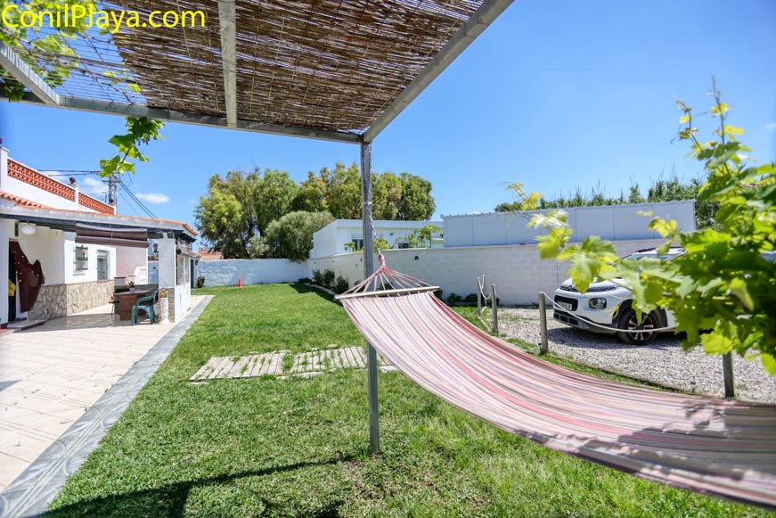 Jardín privado con hamaca y zona de aparcamiento