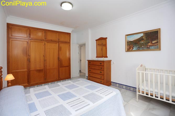 El dormitorio principal cuenta con armario empotrado, comoda y cuna para bebes y niños pequeños.
