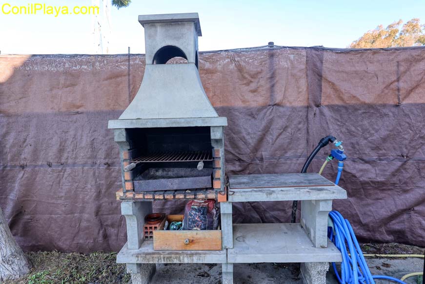 barbacoa con mesa, sillas y sombrilla