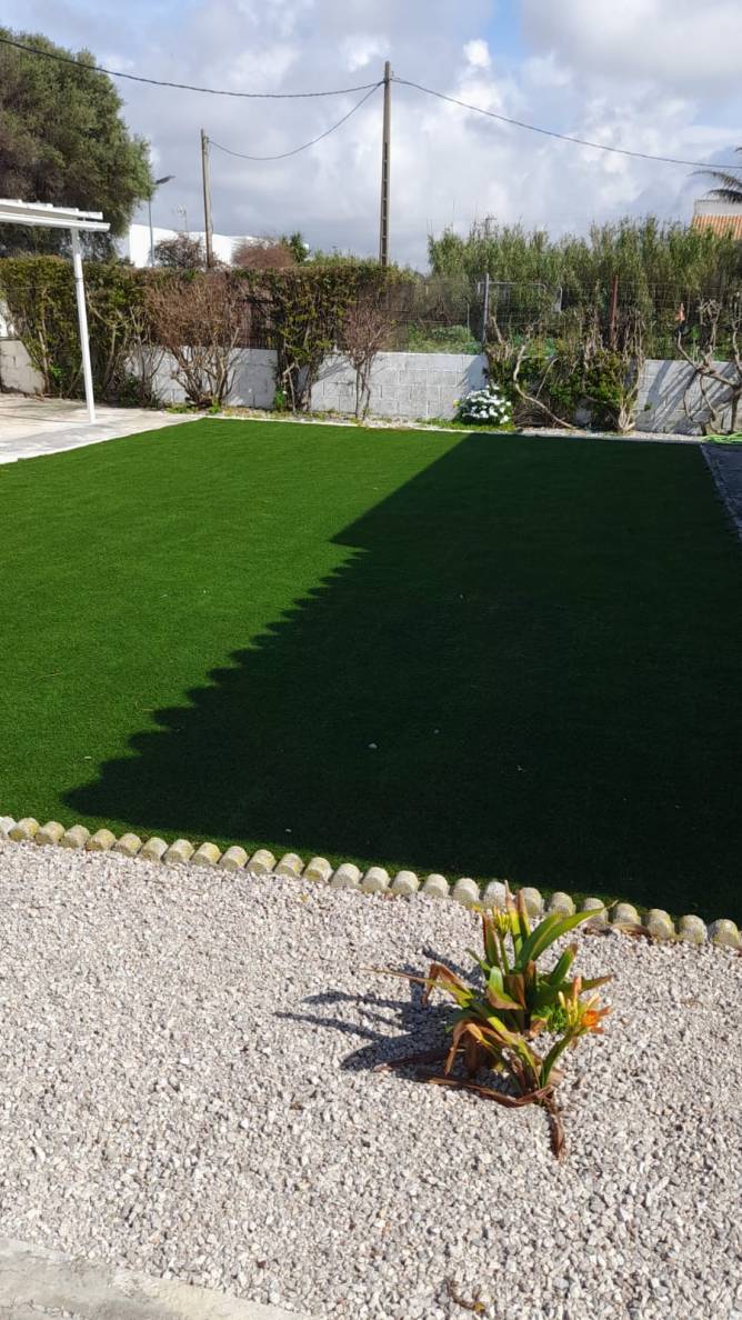 El jardín es amplio y con césped artificial