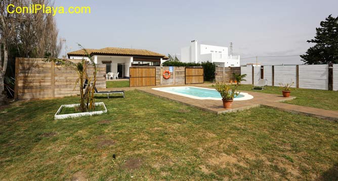 piscina, jardín y al fondo la casa 