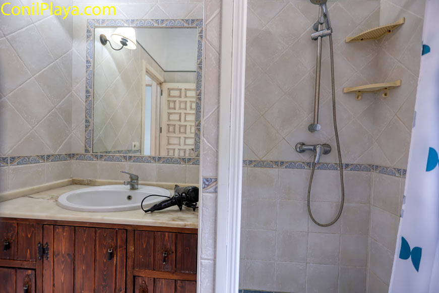 Cuarto de baño con ducha, lavabo de mármol y espejo grande