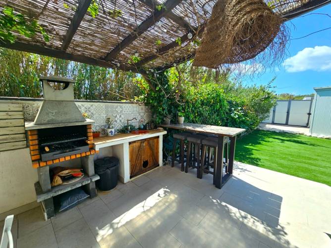 Barbacoa lista para parrilladas de verano Zona de barbacoa de obra y barra exterior con taburetes