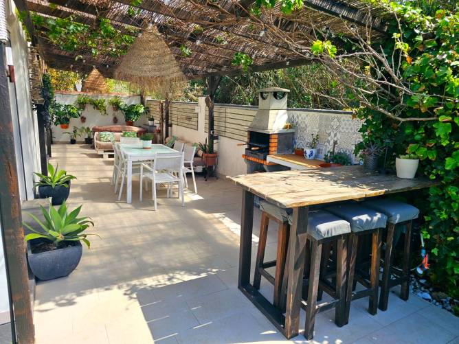 Cenador exterior con sombra natural Mesa de comedor exterior bajo pérgola de cañizo y vides