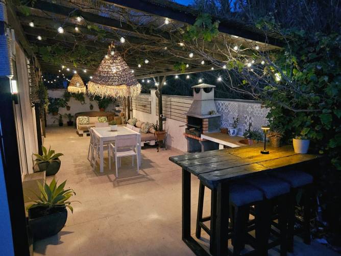 Iluminación nocturna mágica en la terraza Terraza de alquiler vacacional iluminada de noche con guirnaldas