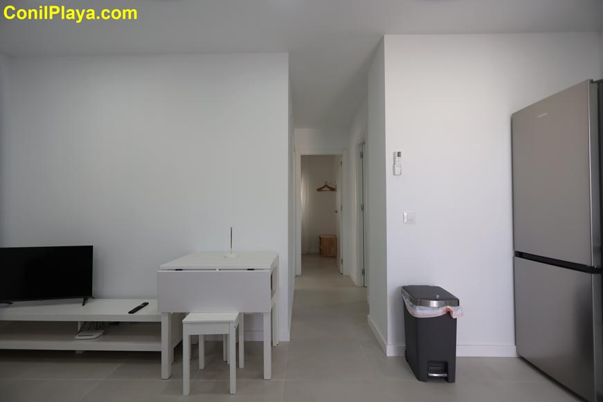 Comedor con mesa blanca y acceso a pasillo interior moderno y minimalista