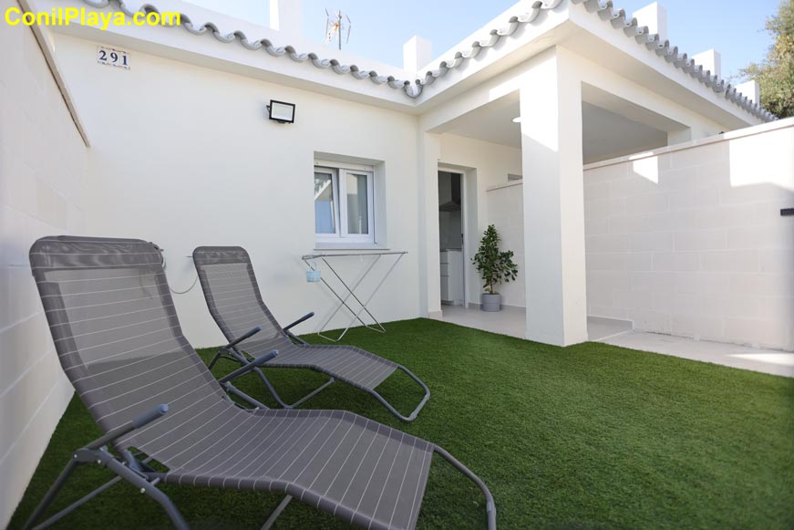 Jardín privado con tumbonas y zona de acceso a la casa